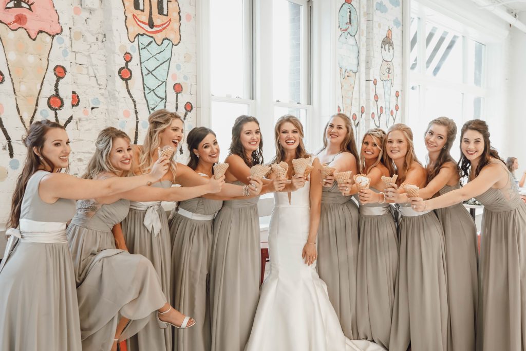 a bride and her maids eat ice cream together on wedding day