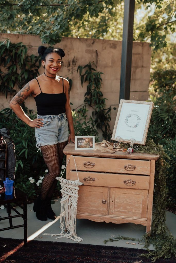 Girl poses beside a dresser at Vendorpalooza.