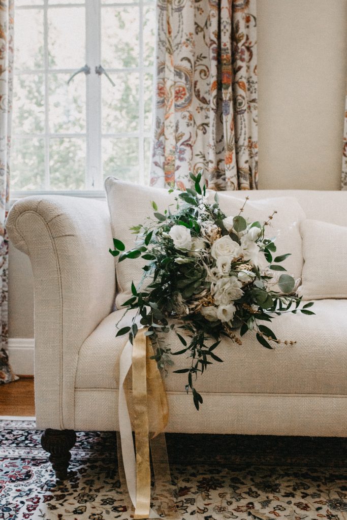 Bouquet on cream couch with trailing ribbons