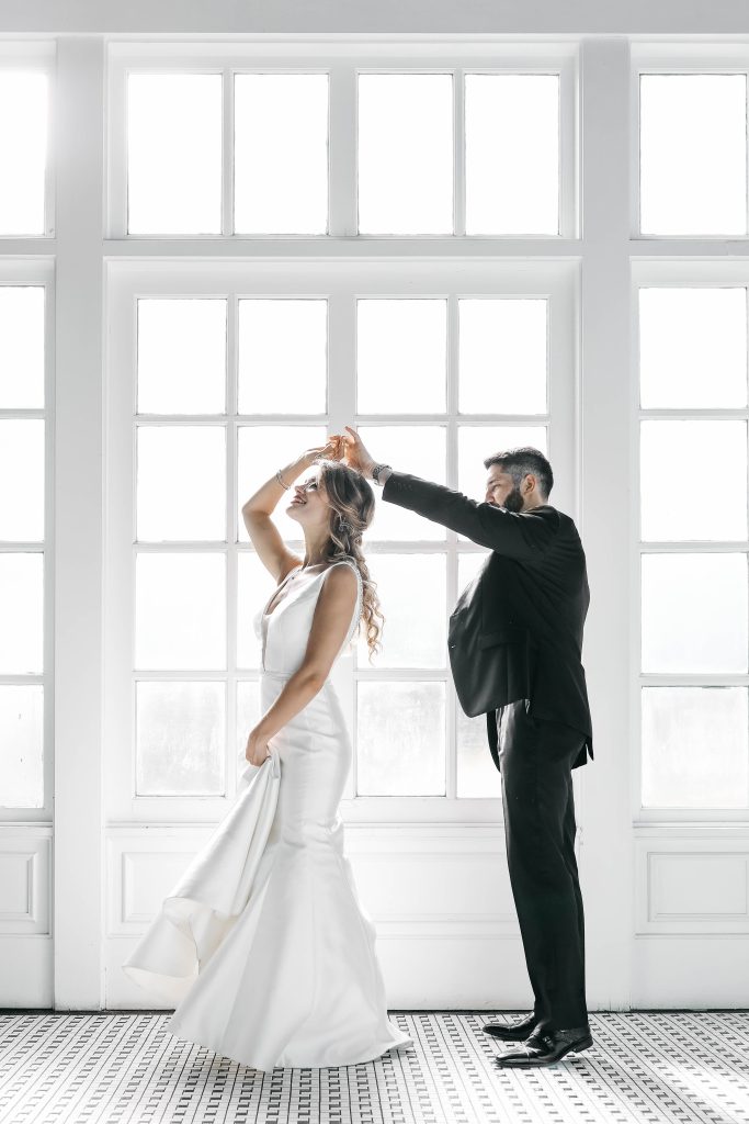 bride and groom dancing in front of frosted windows
