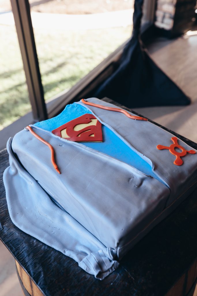 The groom's cake with nods to orange theory and superman.