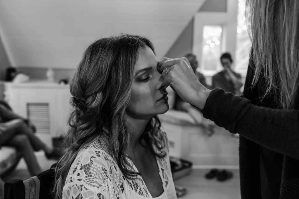 Bride gets her glam makeup fixed with a boho braid in her hair